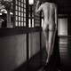 Back of a nude asian woman walking along a dark corridor in Japanese h... (thumbnail)