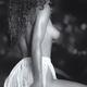 Erotic black and white of a beautiful sexy topless woman sitting half... (thumbnail)