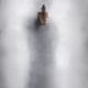 Mysterious man behind glass pointing a gun out of bright white light T... (thumbnail)