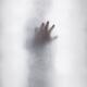 Man with outstretched hand touching hazy glass surface out from a brig... (thumbnail)