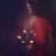 Mysterious dark portrait of a woman looking at a lily flower in her ha... (thumbnail)