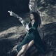Woman in green dress lying on a dried tree with a dreamy relaxed expre... (thumbnail)