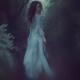 Woman walking into a forest looking back over her shoulder... (thumbnail)