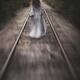 Dramatic concept of a woman in a long dress walking away along railroa... (thumbnail)