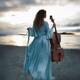 Atmospheric portrait of a woman in a vintage dress standing with a cel... (thumbnail)