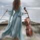 Woman in a long vintage dress standing gracefully by the ocean shore w... (thumbnail)