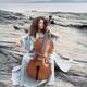 Woman thoughtfully playing cello on an ocean shore in sunrise scenery... (thumbnail)