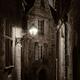 Dramatic fine art nighttime scenery of an old street lit by a lamp in... (thumbnail)