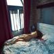 Woman lying asleep naked on a bed in morning light from a window... (thumbnail)