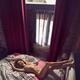 Beautiful nude woman lying on a bed naked with her legs on a headboard... (thumbnail)