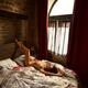 Artistic sensual portrait of a sexy nude woman lying on a bed in a dim... (thumbnail)