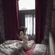 Woman just awaken in the morning stretching in bed by the window... (thumbnail)