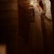 Woman walking down a dark spiral staircase with an oil lamp in her han... (thumbnail)