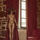 Sexy nude woman in a hat standing naked by a window curtain... (thumbnail)