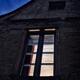 Closed window of an old French stone house under dark twilight skies w... (thumbnail)