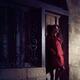 Woman standing on the street at night leaning against a locked door of... (thumbnail)