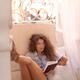 Young woman in glasses with sexy long legs reading a book reclining by... (thumbnail)
