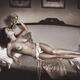 Beautiful sexy nude woman lying on a couch naked with grapes in her ha... (thumbnail)
