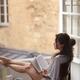 Young French woman reading a book in the morning by an open window Art... (thumbnail)
