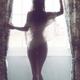 Silhouette of a nude woman back by the window in bright light in a she... (thumbnail)