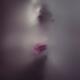 Ghostly woman face with a pink rose behind a veil of dense white suffo... (thumbnail)