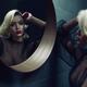 Sexy blond woman looking into a round mirror... (thumbnail)