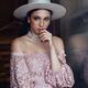 Elegant young woman in pink lace dress and white hat with a thoughtful... (thumbnail)