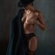 Boudoir portrait of mysterious half naked woman in black hat and linge... (thumbnail)