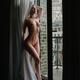 Erotic portrait of a young woman standing fully nude by an open balcon... (thumbnail)