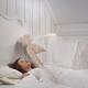 Woman sleeping in bed while her ethereal body rising above Lucid dream... (thumbnail)