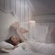Woman sleeping in bed lucid dreaming her ethereal body rising above he... (thumbnail)