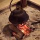 Japanese cast iron kettle Kama on burning firewood in floor hearth... (thumbnail)