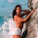Sexy topless exotic woman at a sea shore leaning against a rock with c... (thumbnail)
