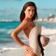 Sexy sun-tanned exotic woman at a beach covering her nude body with a... (thumbnail)