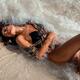 Sexy woman in swimsuit lying on a sandy shore with splashing waves of... (thumbnail)