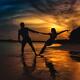 Man and woman dancing at a seashore in dramatic sunset Couple holding... (thumbnail)