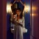 Beautiful woman in evening gown lighting a candle in her hand with an... (thumbnail)