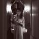 Woman in evening gown lighting a candle in her hand with a mysterious... (thumbnail)