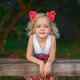 Cute smiling little girl with pink flowers in her blond hair... (thumbnail)