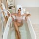 Sexy woman in underwear sitting in a bathtub full of water with her ha... (thumbnail)