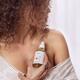 Closeup of woman bare shoulder with a body oil bottle in her hand Skin... (thumbnail)