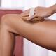 Closeup of woman hand with a dry brush massaging her thighs Personal s... (thumbnail)
