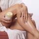 Woman rubbing her legs with a body cream skin care product Closeup of... (thumbnail)