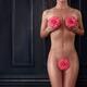 Beautiful nude woman covering her sexy naked body with pink camellia f... (thumbnail)