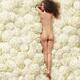 Woman lying nude on white hydrangea flowers view of her naked back fro... (thumbnail)