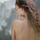 Beautiful nude woman bare back with long brown hair and a flower in he... (thumbnail)