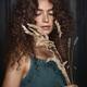 Cute girl with curly hair and expressive big eyes looking down on flow... (thumbnail)