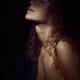 Sensual dramatic closeup of woman face and neck and bare chest in shad... (thumbnail)