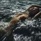 Woman lying naked in turbulent water of a river or sea her bare breast... (thumbnail)