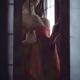 Beautiful Asian woman in undone red kimono standing by an open shoji w... (thumbnail)